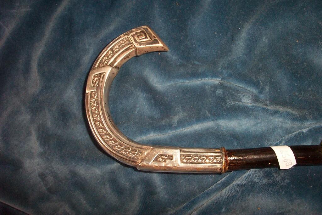 Appraisal: A walking cane with white metal mounted handle of stylised