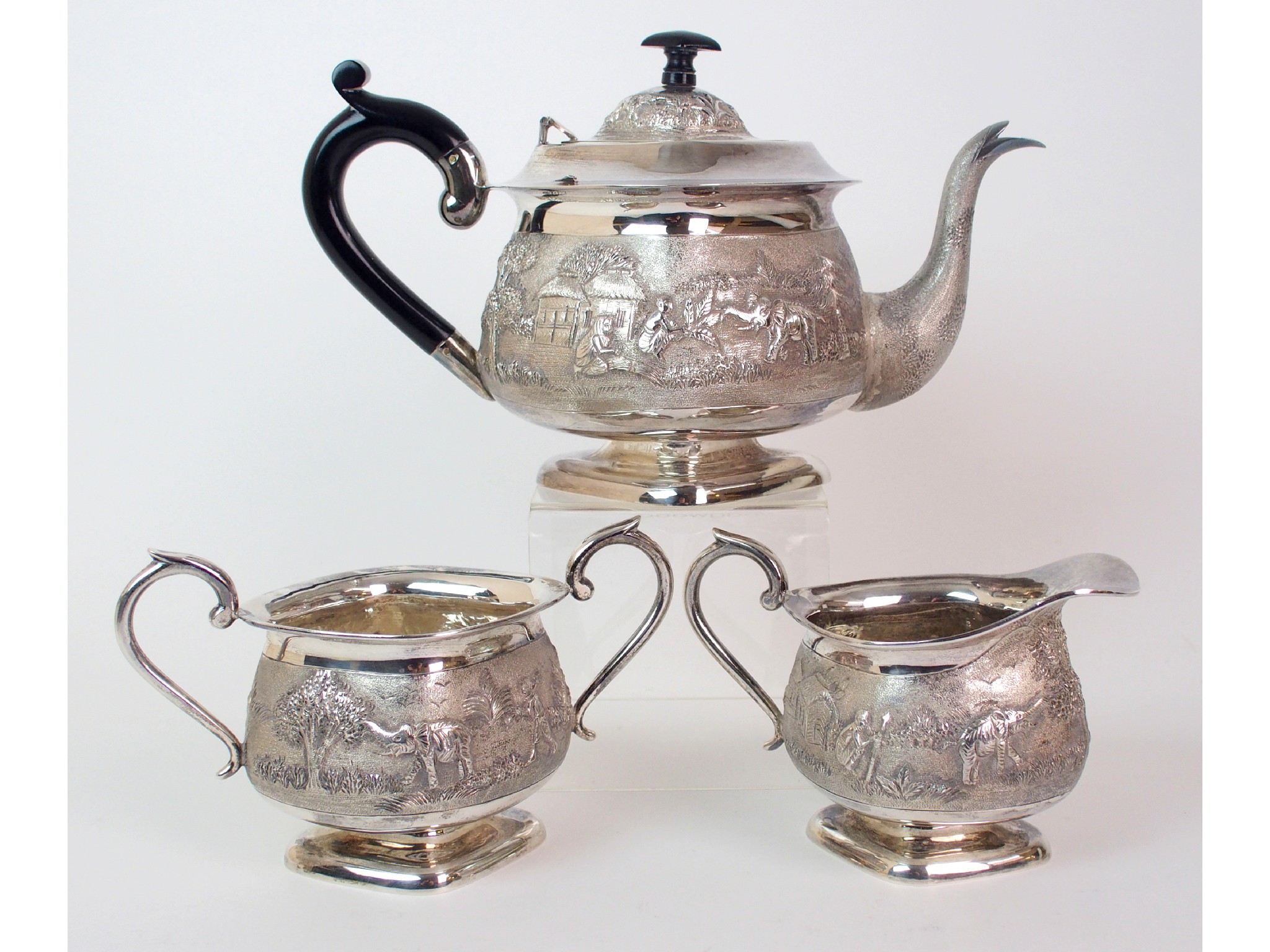 Appraisal: A Burmese silver three piece tea serviceembossed and chased with