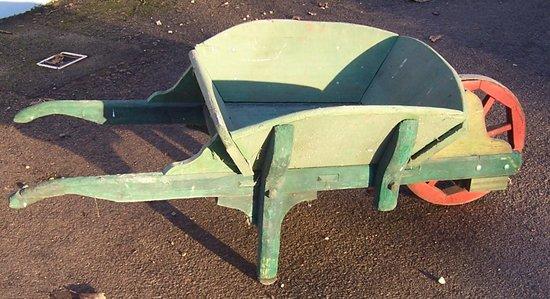 Appraisal: A green painted wheelbarrow with red spoked wheel