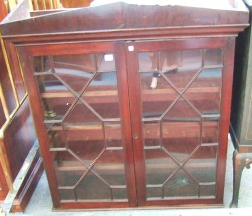 Appraisal: An early th century mahogany bookcase the architectural cornice over