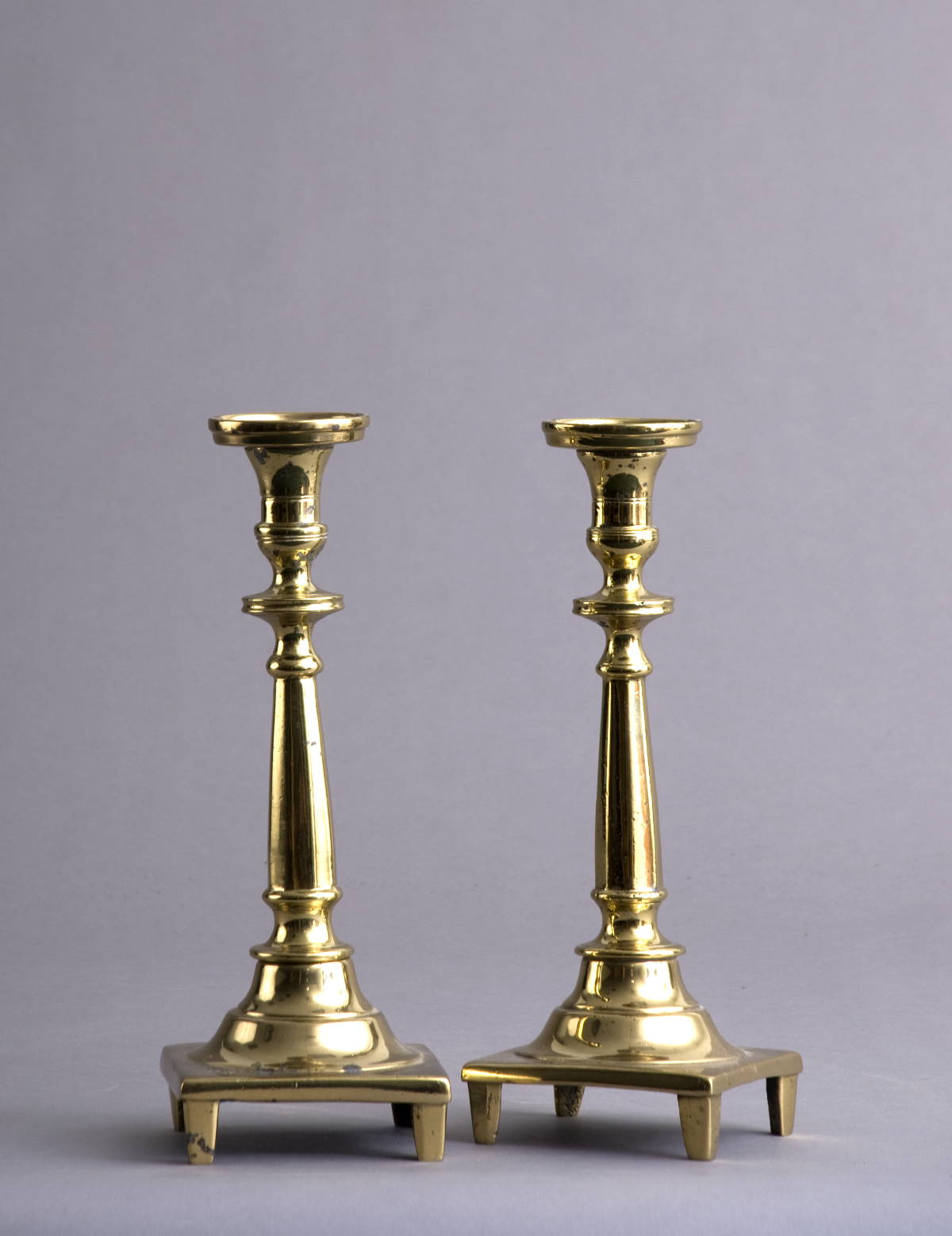 Appraisal: PAIR OF CONTINENTAL BRASS CANDLESTICKS Each ring-turned nozzle above a