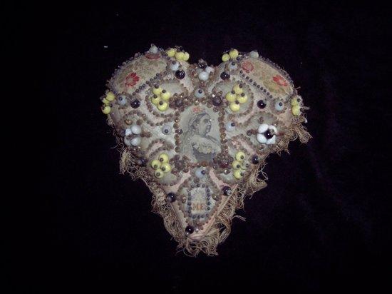 Appraisal: A heart shaped pinwork cushion with central image of Queen