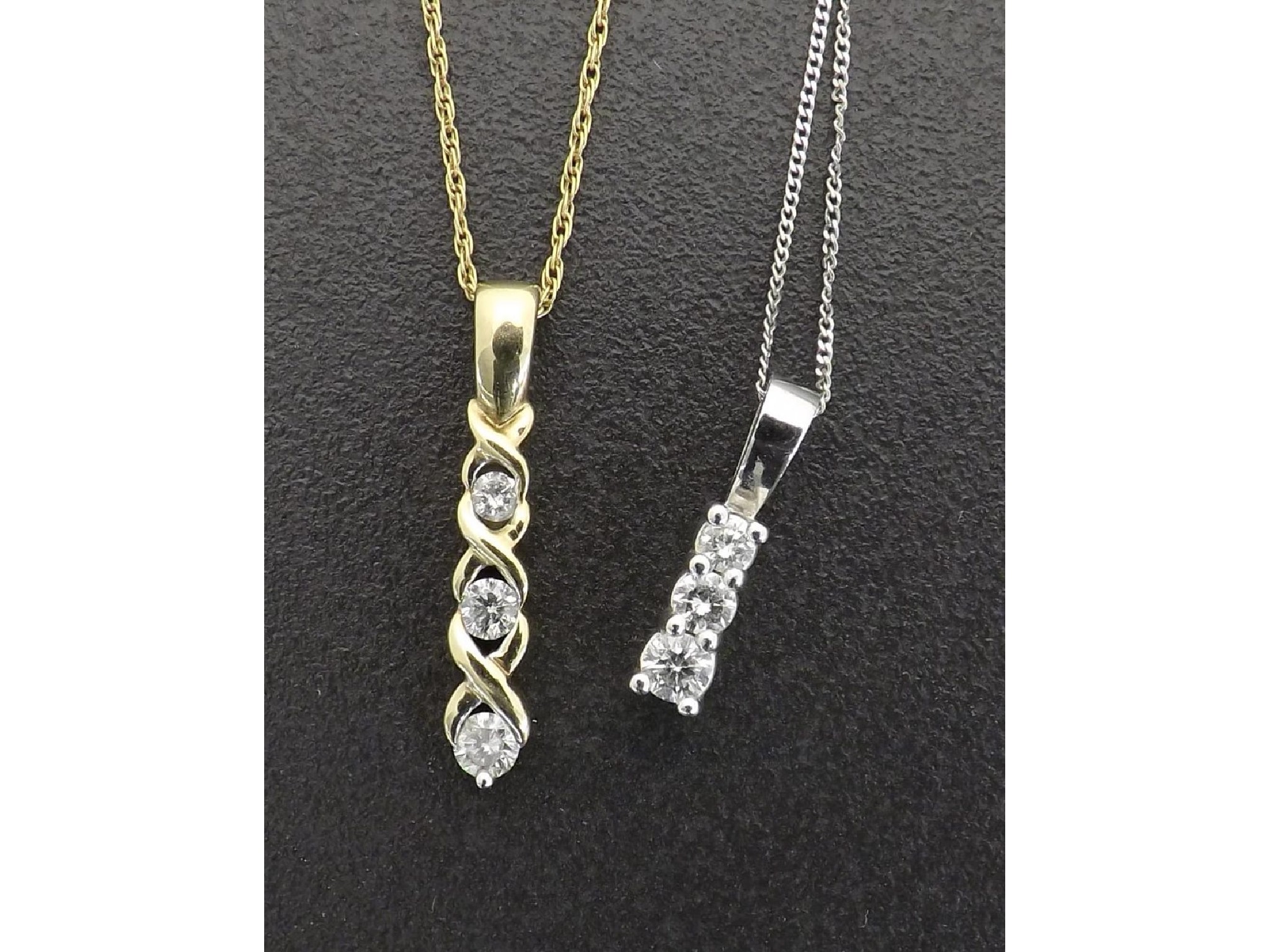 Appraisal: Two ct three stone diamond pendants on necklets gm