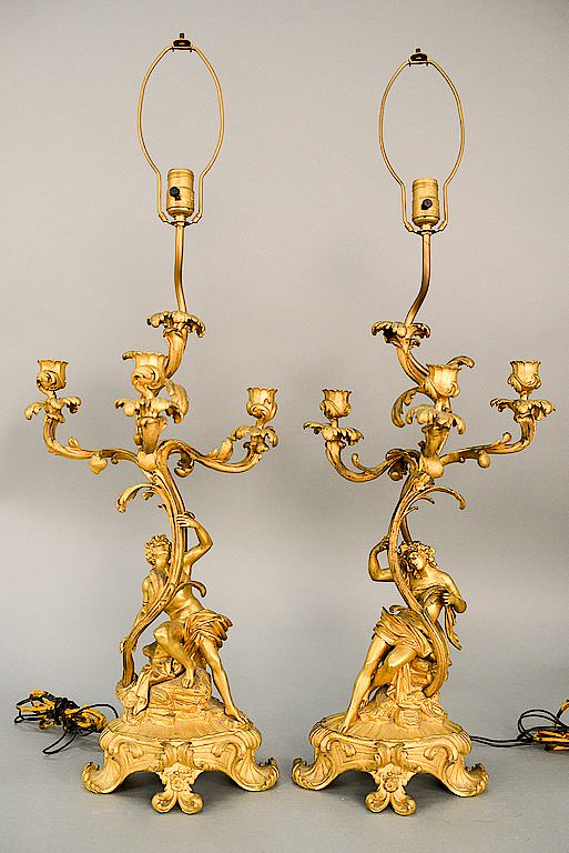 Appraisal: Pair of figural gilt bronze candelabras each having scrolling foliate