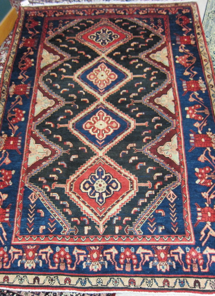 Appraisal: PERSIAN TRIBAL CARPET featuring a column of four diamond-shaped medallions