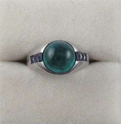 Appraisal: A cabochon emerald ring The circular cut emerald is set