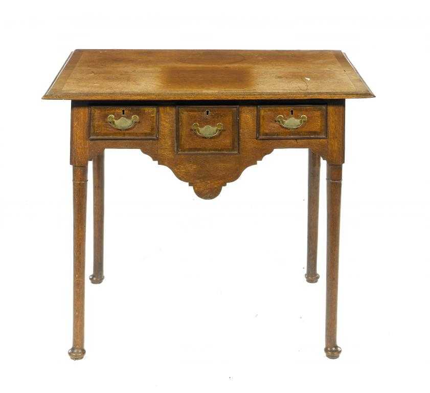 Appraisal: A GEORGE III OAK LOWBOY with oversailing crossbanded top and