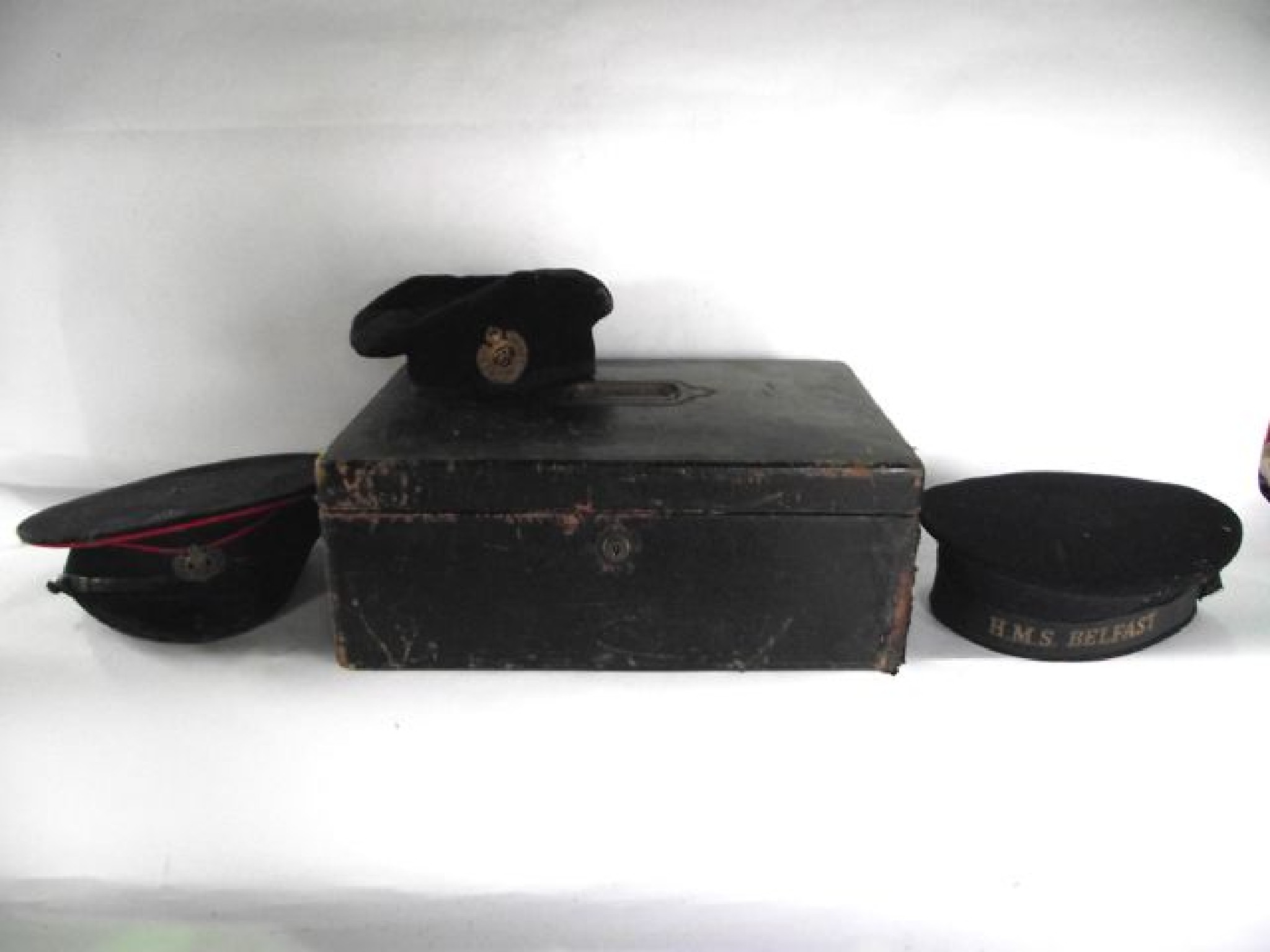 Appraisal: A sailor's cap with ribbon reading HMS Belfast with paper