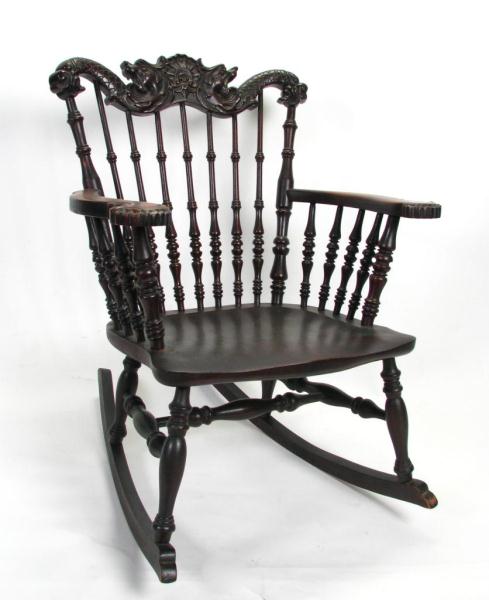 Appraisal: Turn-of-the-Century Mahogany Spindle Rocker with carved serpent motif