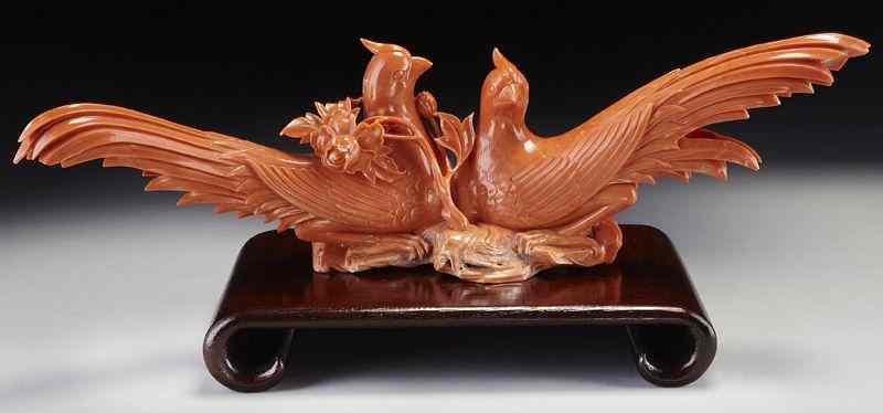 Appraisal: Chinese carved red coral pigeons perched on a International buyers