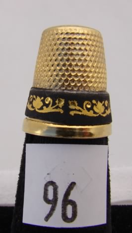 Appraisal: Gold tone thimble with black band with gold floral design