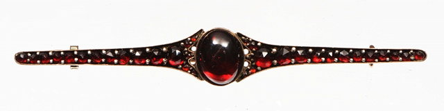 Appraisal: A VICTORIAN GARNET SET BAR BROOCH central oval cabochon garnet