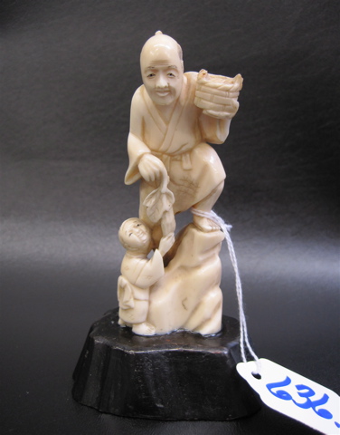 Appraisal: JAPANESE CARVED IVORY FIGURE Man standing on rock holding a