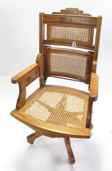 Appraisal: An antique Eastlake style carved frame physician's office chair caned