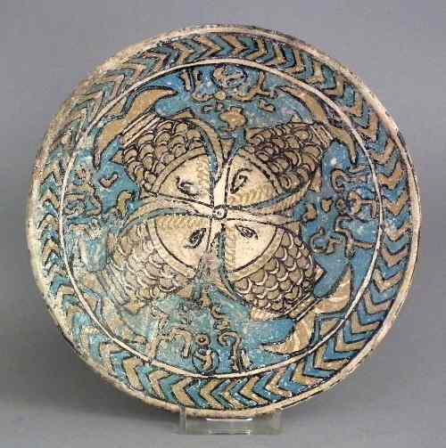 Appraisal: An early Islamic pottery bowl painted with four fish and