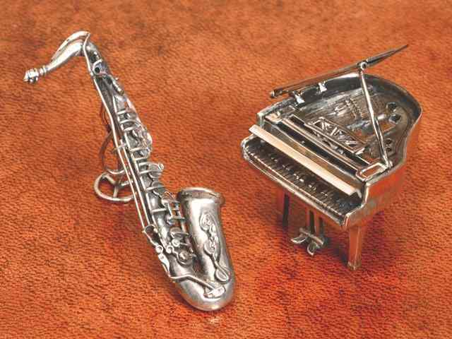 Appraisal: A CONTINENTAL MINIATURE GRAND PIANO and a saxophone with stand