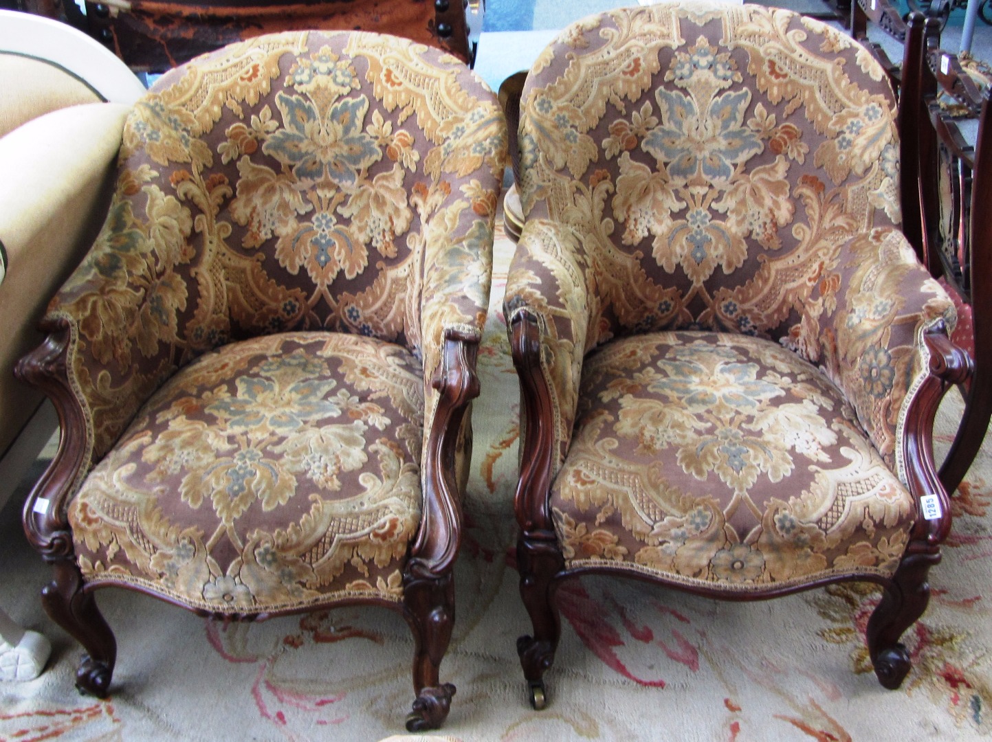 Appraisal: A pair of Victorian rosewood framed tub back easy armchairs