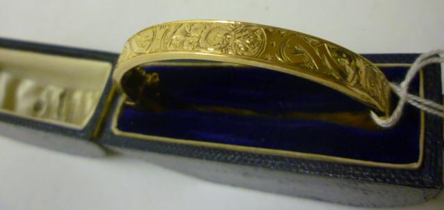 Appraisal: AN EDWARDIAN CT GOLD HOLLOW STIFF HINGED BANGLE the upper