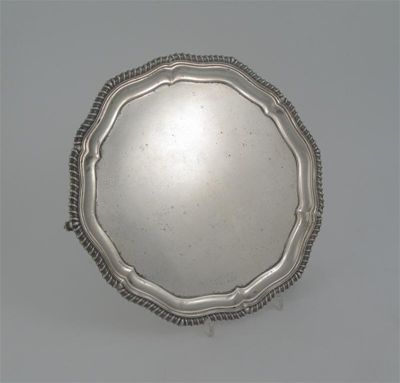 Appraisal: An Edwardian salver shaped circular with a gadrooned border and