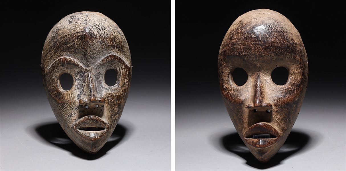 Appraisal: Two carved wooden masks in the style of the Dan