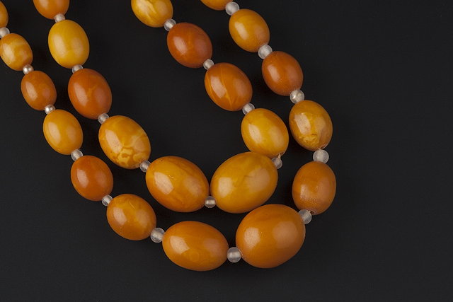 Appraisal: AN AMBER BEAD NECKLACE comprising two strands of graduated oval