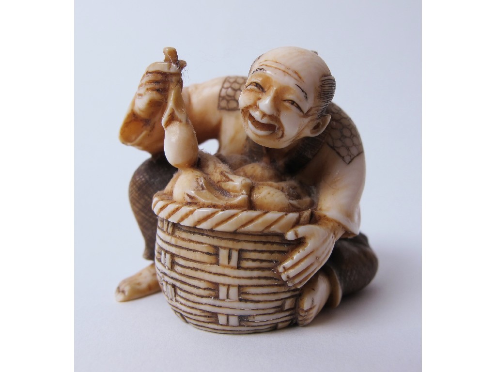 Appraisal: A Japanese carved ivory netsuke of a fruit vendor seated