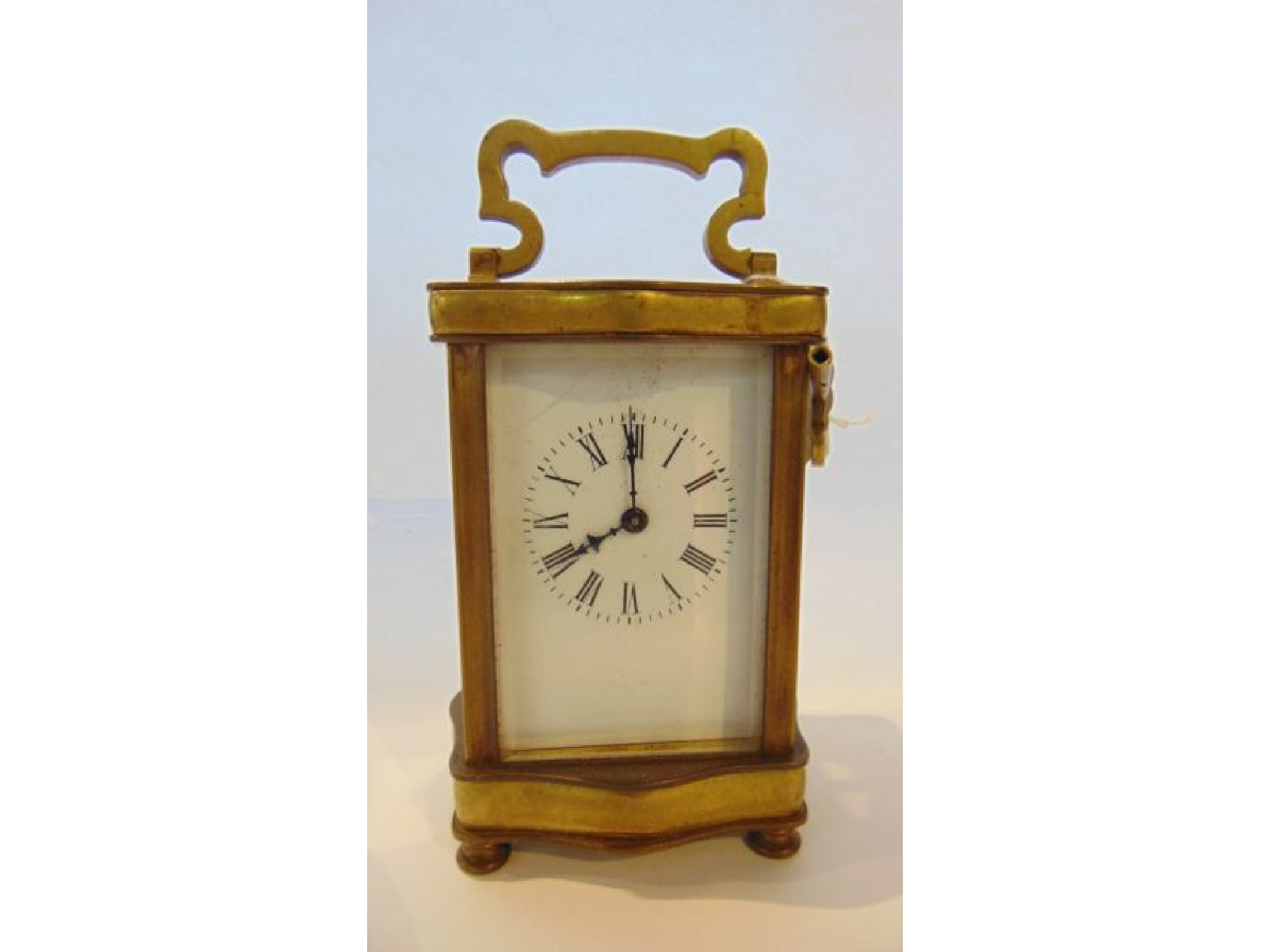 Appraisal: A brass carriage clock set within a shaped case with