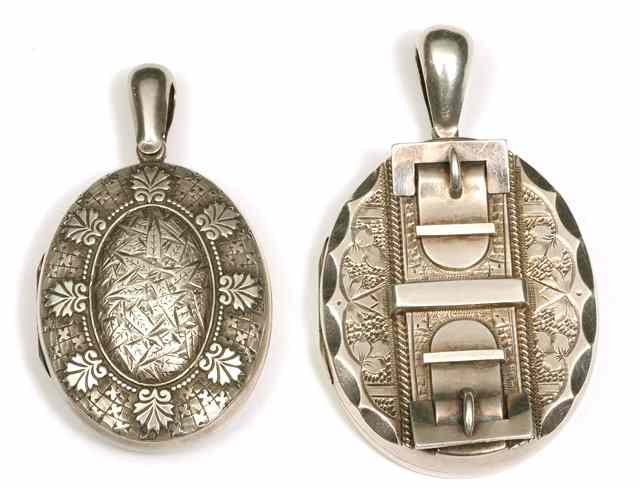 Appraisal: A VICTORIAN OVAL SILVER LOCKET with applied buckles and engraved