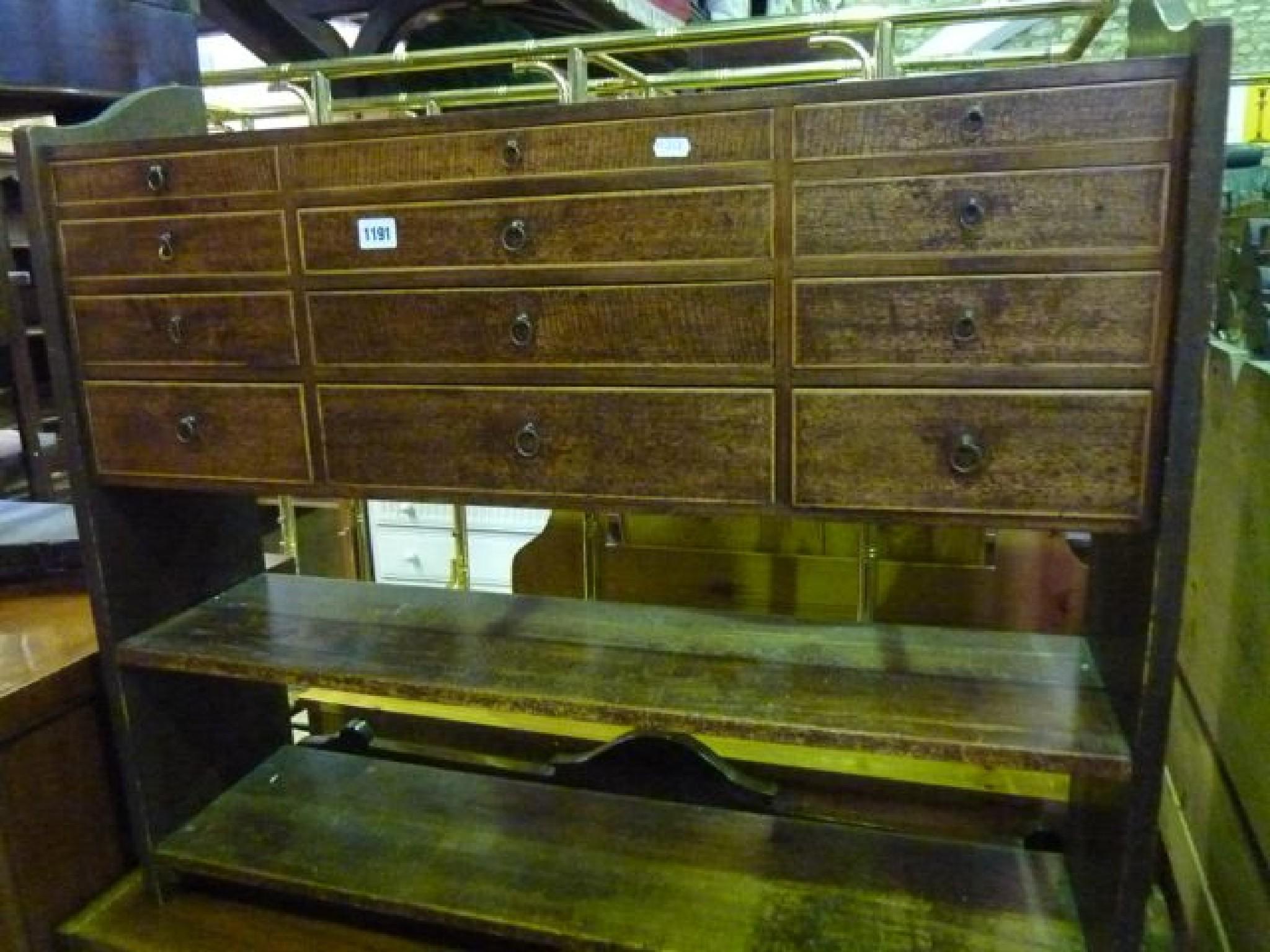 Appraisal: A nest of twelve small drawers mounted within an associated