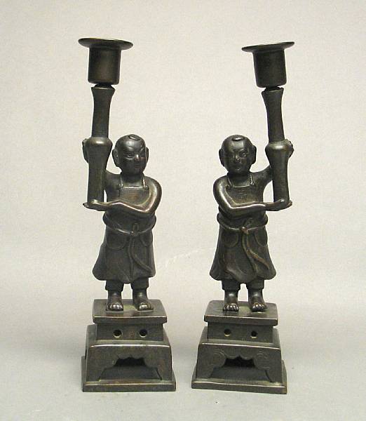 Appraisal: A pair of bronze candle sticks in a form of