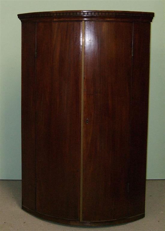 Appraisal: George III mahogany bow-fronted corner wall cupboard with dentil cornice