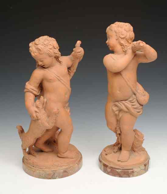 Appraisal: A PAIR OF ITALIAN TERRACOTTA PUTTI each of huntsman form