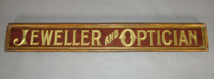 Appraisal: An Edwardian oak and glazed 'Jeweller and Optician' shop sign