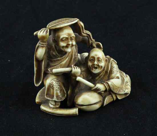 Appraisal: A Meiji period ivory netsuke carved as two entertainers one