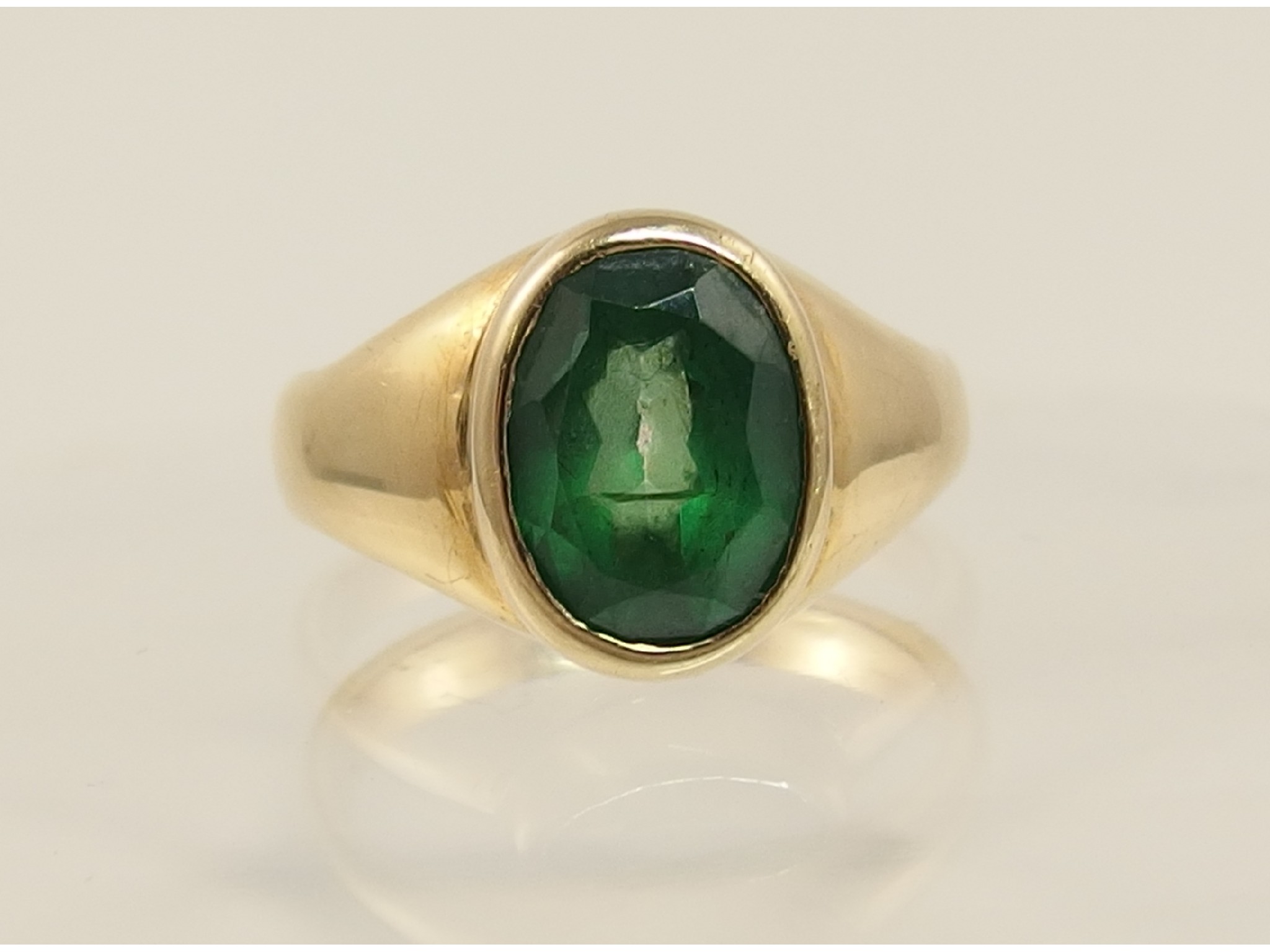 Appraisal: A yellow metal ring set with a green gem stone