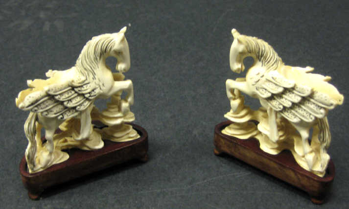 Appraisal: PAIR OF CHINESE IVORY WINGED HORSES Carved and inked with