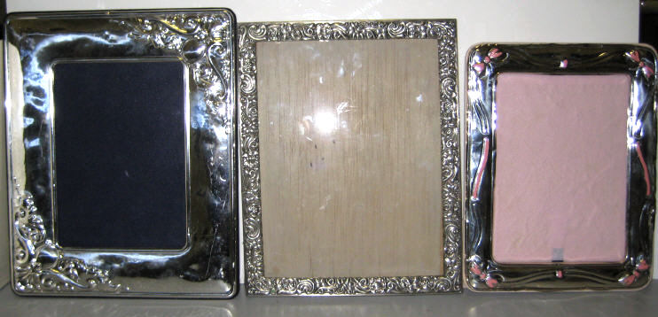 Appraisal: THREE ASSORTED STERLING FRAMES Each repousse decorated two with easel