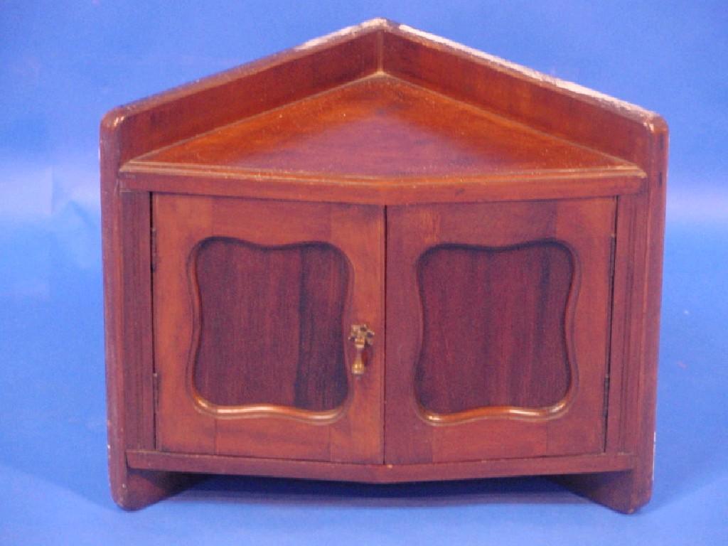 Appraisal: A late thC mahogany hanging corner cabinet with two panelled