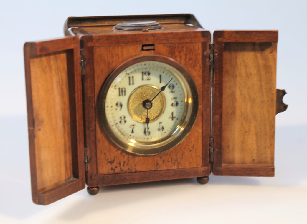 Appraisal: An early thC campaign style travelling clock in a walnut