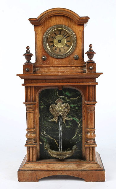 Appraisal: A CONTINENTAL WALNUT CASED FOUNTAIN CLOCK in architectural case with