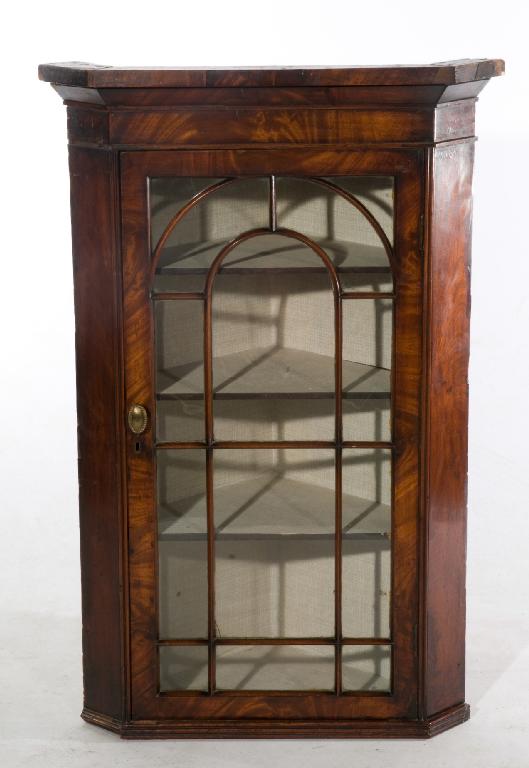 Appraisal: GEORGE III MAHOGANY-VENEERED HANGING CORNER CUPBOARD the projecting cornice above