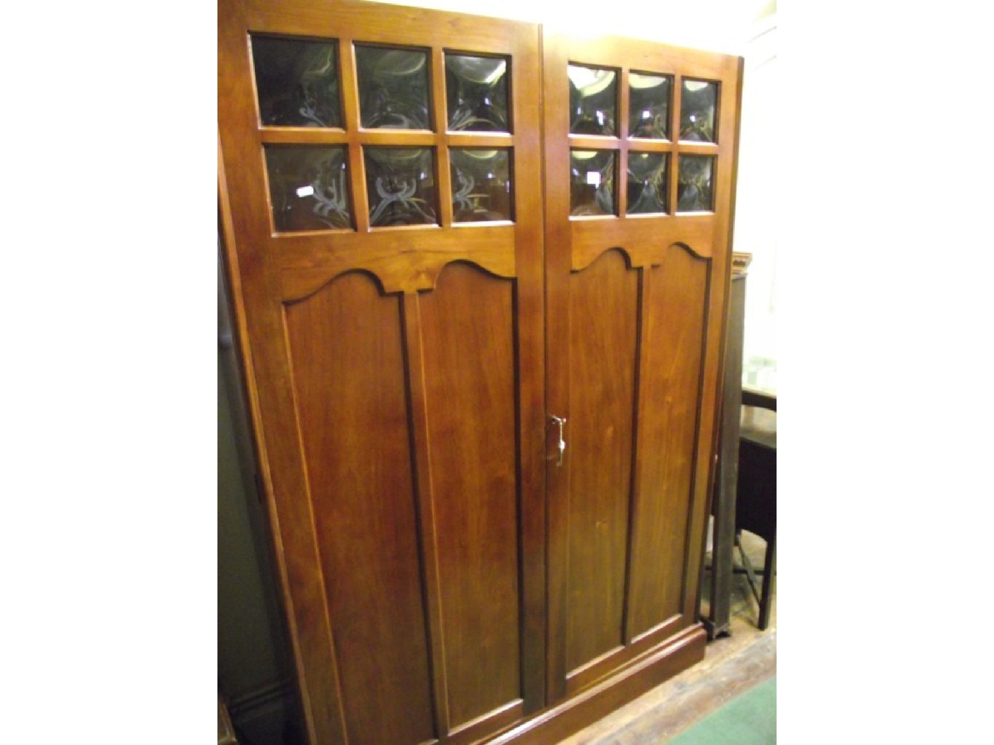 Appraisal: An enclosed walnut bookcase of full height the panelled doors