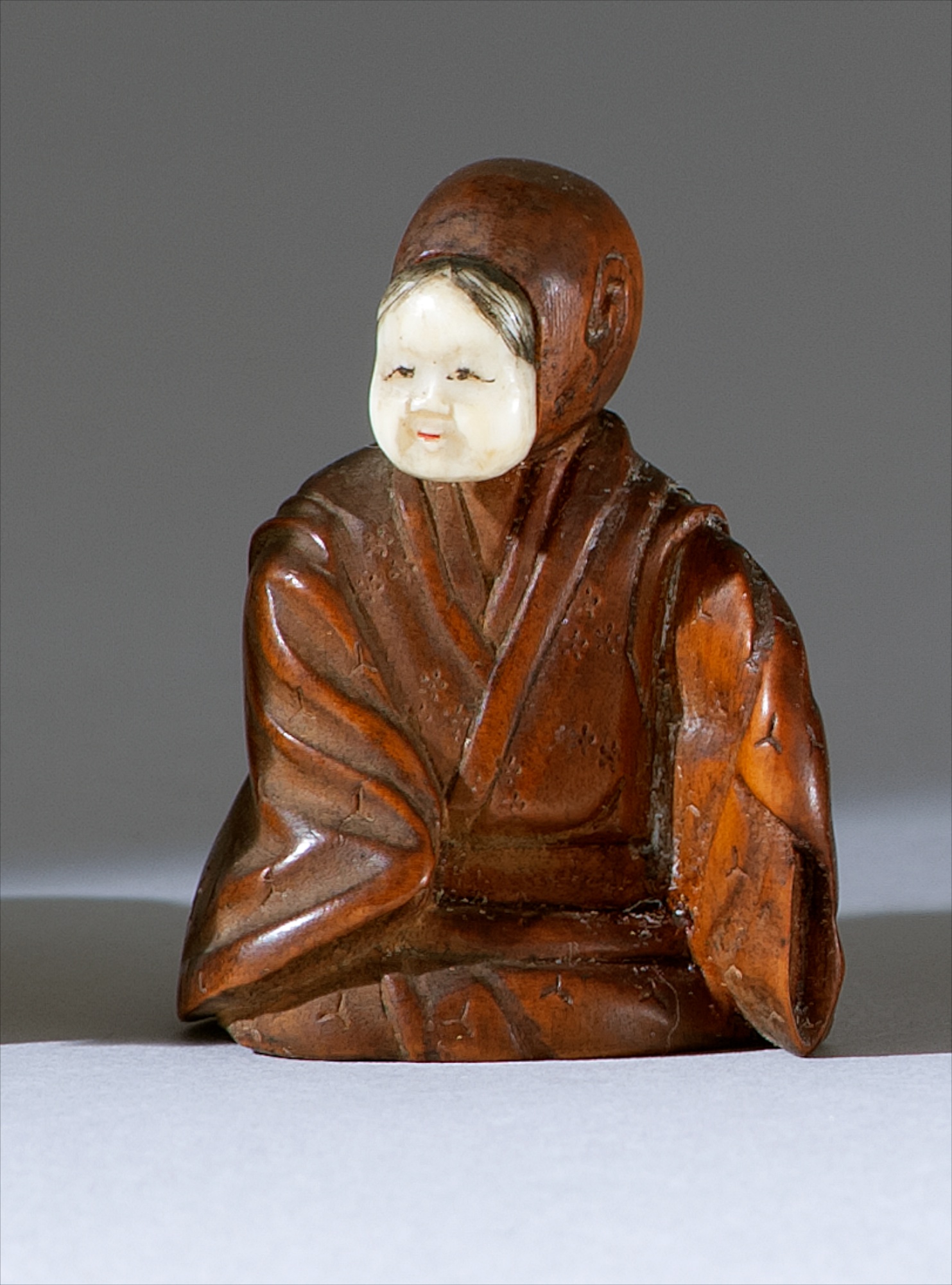 Appraisal: WOOD NETSUKE OKIMONO Mid- th CenturyDepicting a seated actor wearing