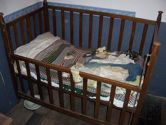 Appraisal: A child's fold-away cot fitted a sliding side panel cm