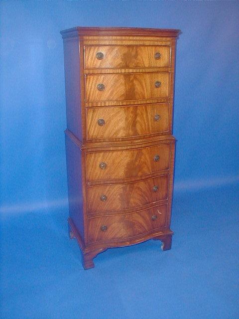 Appraisal: A reproduction flamed mahogany serpentine chest-on-chest high wide