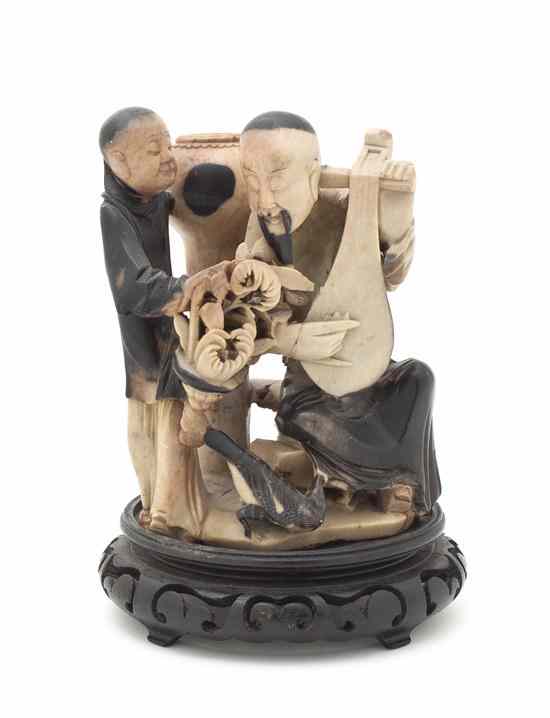 Appraisal: A Chinese Soapstone Carving depicting a lute player and a