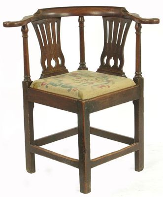 Appraisal: A George III fruitwood corner armchair the scroll arms above