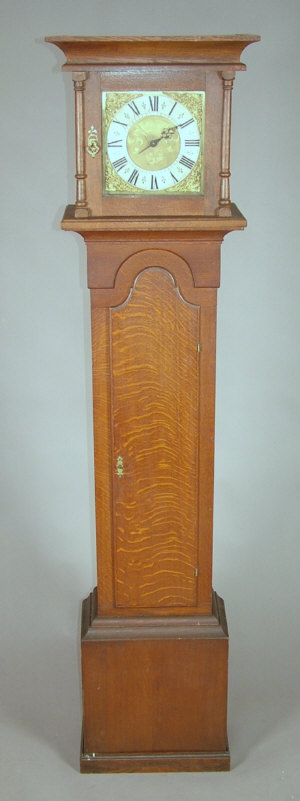 Appraisal: An oak longcase clock with flat top hood the trunk