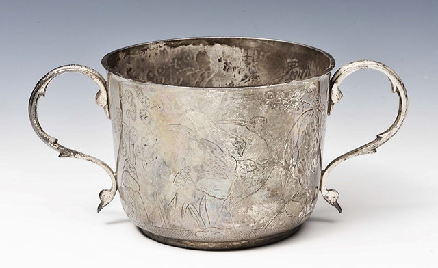 Appraisal: A TWO HANDLED SILVER PORRINGER chased with figures of birds