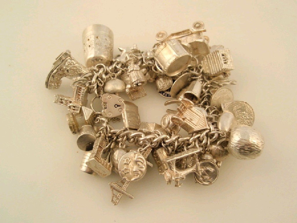 Appraisal: A silver charm bracelet with approximately fifty two charms gms